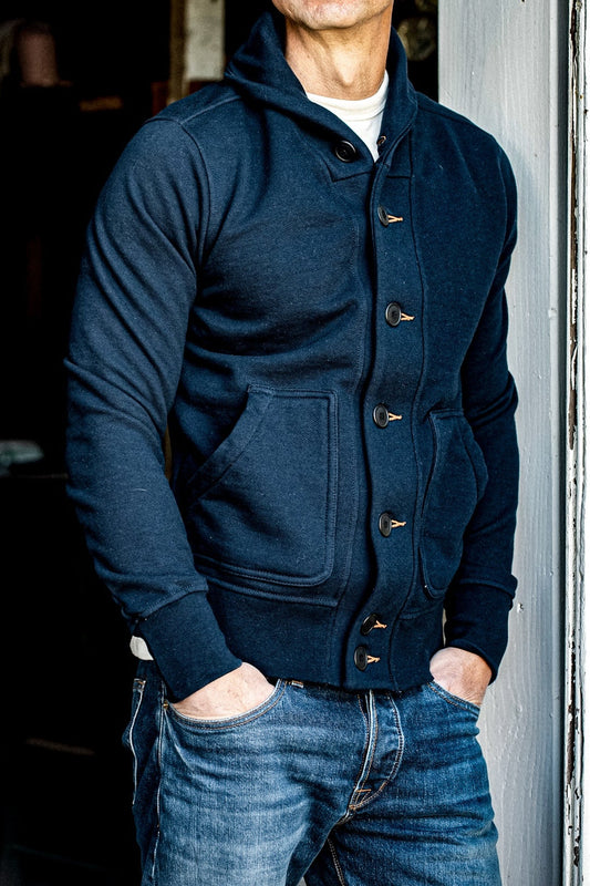 Navy shawl collar French terry cardigan worn over a cream tee with selvedge denim jeans.
