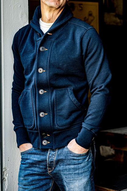 Navy shawl collar French terry cardigan worn over a white tee with faded blue jeans.