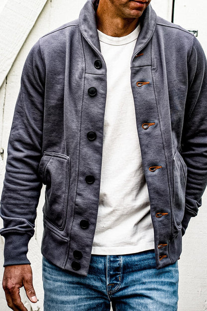 Shawl collar French terry cardigan in pebble grey with black buttons and tobacco contrast keyholes, worn open over a white.