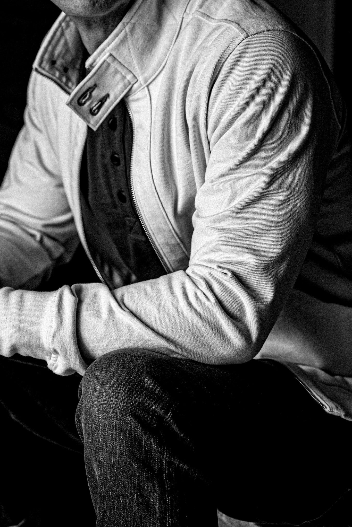 Man wearing a WiesMade Stinson cotton moto jacket with brass zipper, shown in black and white.