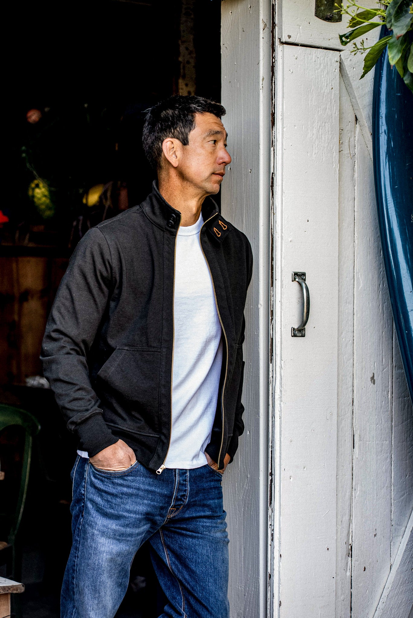 Man in charcoal Stinson cotton moto jacket, worn open over a white tee with jeans.