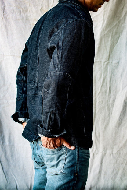 Side view of the men's denim blazer in dark indigo, showing the double-layered elbow patch and side pocket.