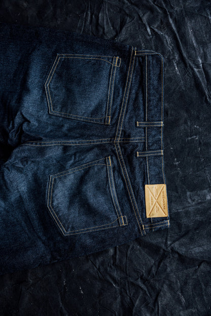 Folded ocean wash American made jeans showing back pockets, contrast stitching, and WiesMade leather patch.