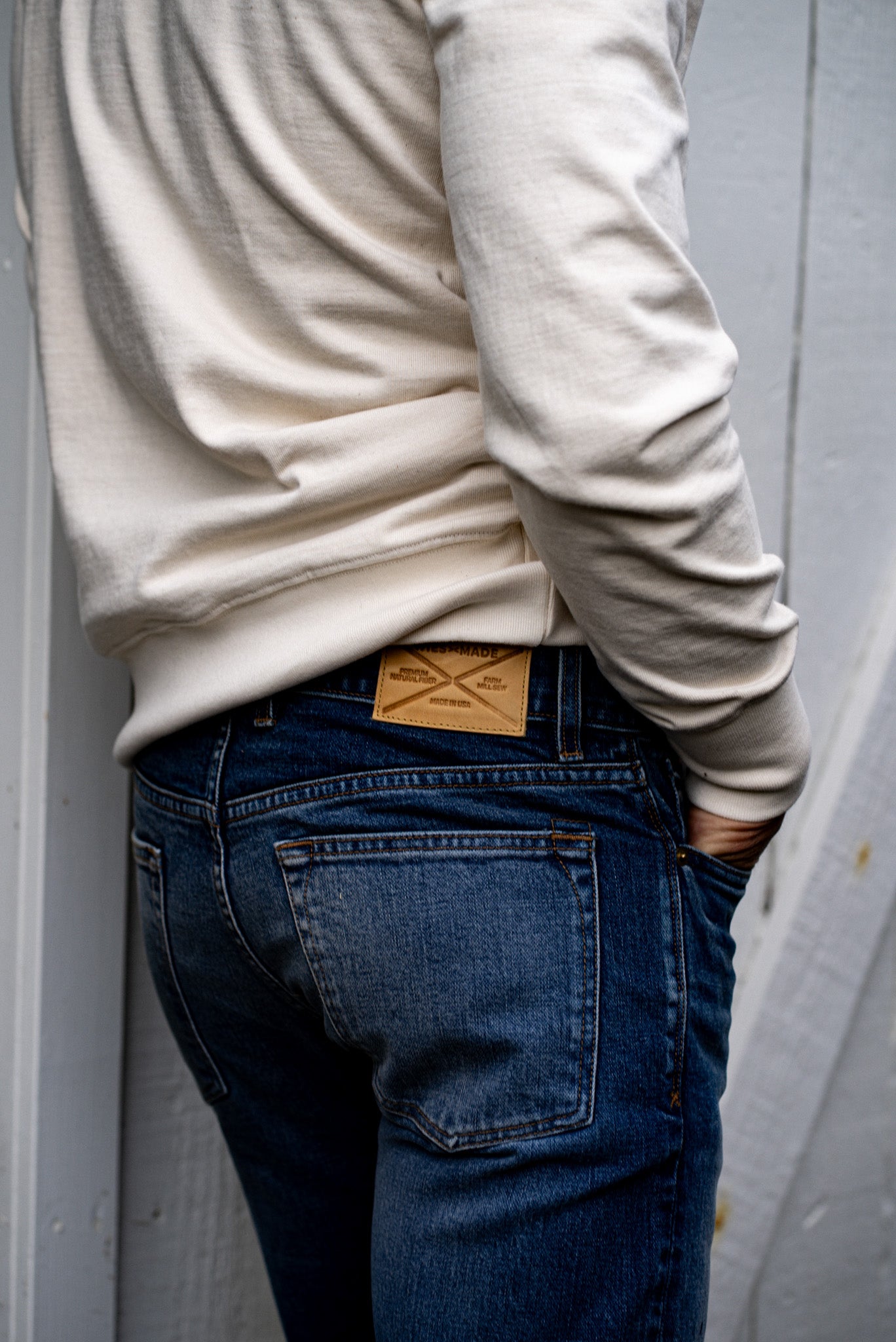 Back view of men's slim fit denim jeans made in USA with leather brand patch