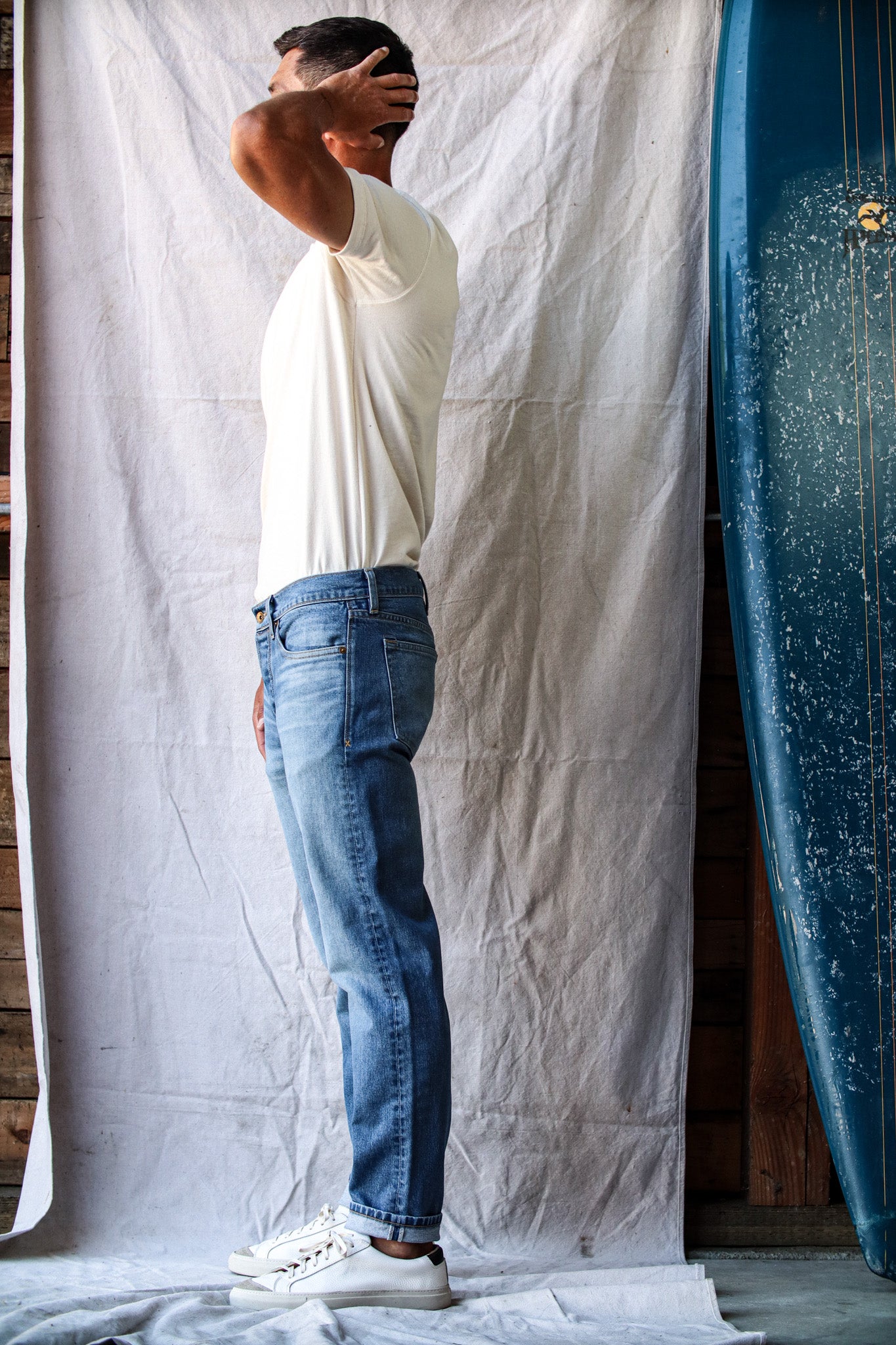 Men’s premium salt wash jeans shown on model, featuring a relaxed fit with soft faded wash, subtle whiskering, and a versatile mid-blue tone for a casual, modern look