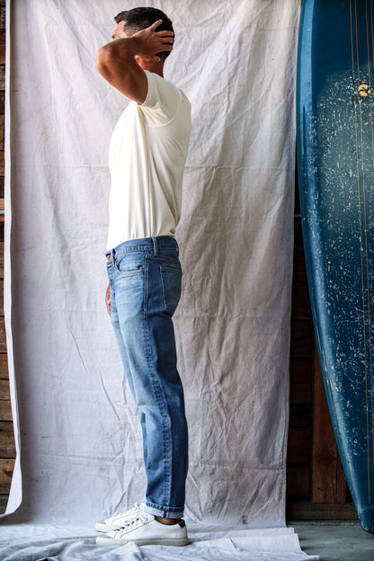 Men’s premium salt wash jeans shown on model, featuring a relaxed fit with soft faded wash, subtle whiskering, and a versatile mid-blue tone for a casual, modern look