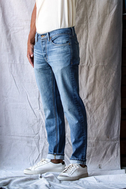 Premium salt wash denim jeans for men shown on model, featuring a light blue faded wash, slim-straight fit, and soft, broken-in texture for a timeless, casual look