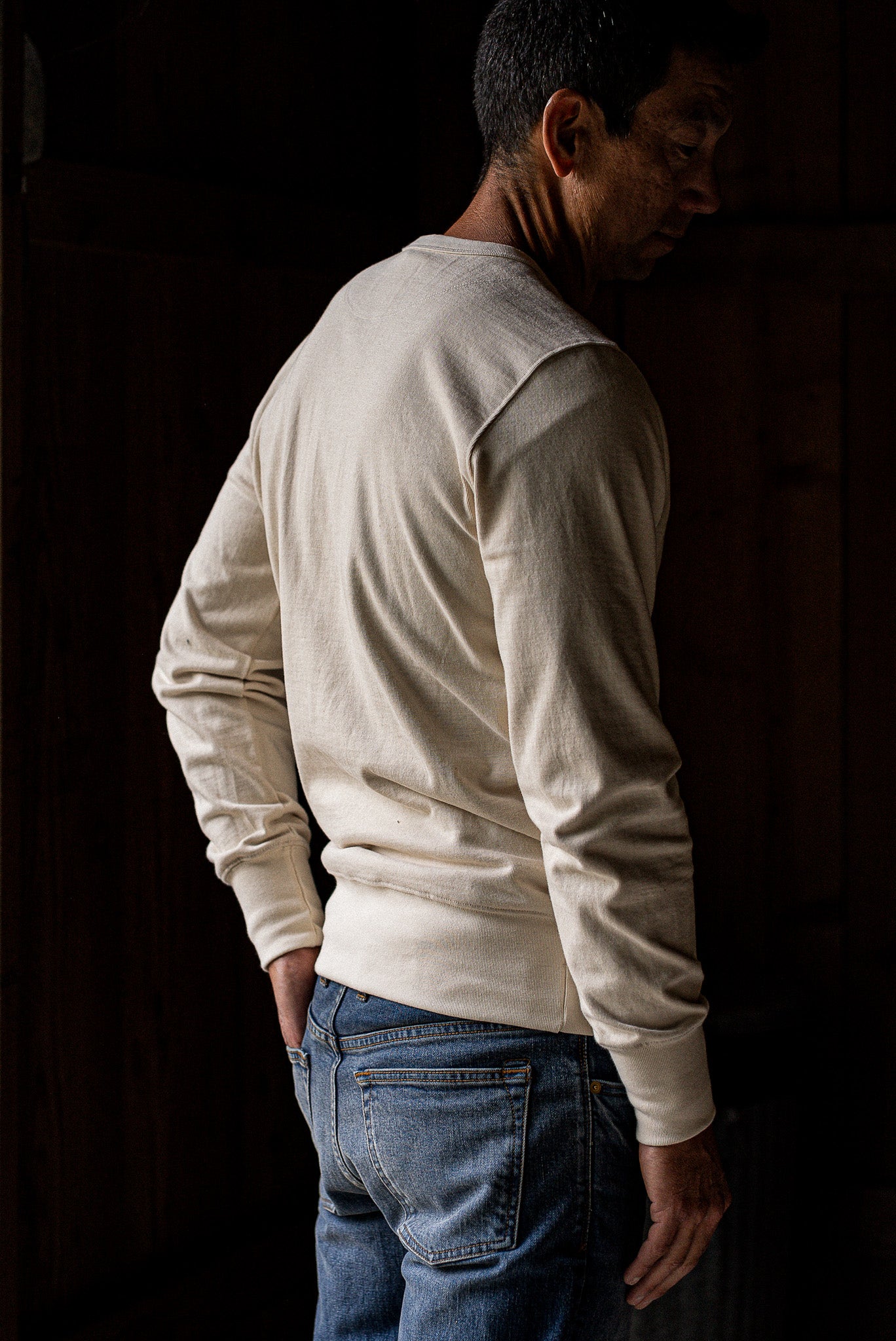 Back view of the natural cotton Stinson rugby jersey pullover worn with faded blue selvedge denim jeans.