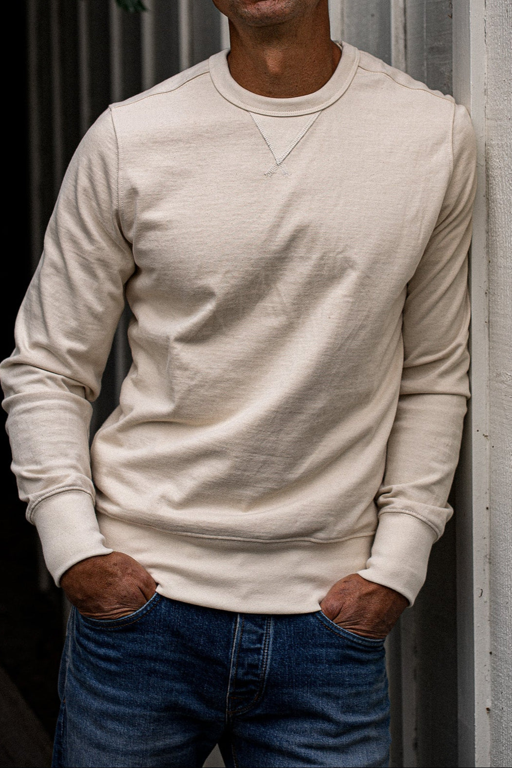 Natural cream Stinson rugby jersey pullover worn with blue denim jeans, hands in pockets.