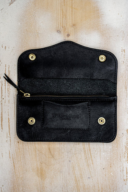 Open black Horween leather wallet showing brass zipper pocket and embossed WiesMade logo.