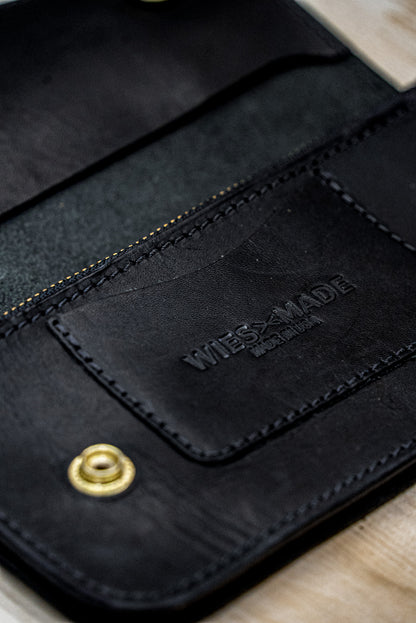 Open black Horween leather wallet interior with card pocket, brass snap, and embossed WiesMade logo.