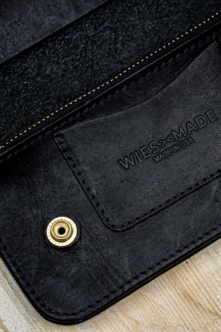 Black Horween leather wallet interior with embossed WiesMade logo, brass snap and zipper.