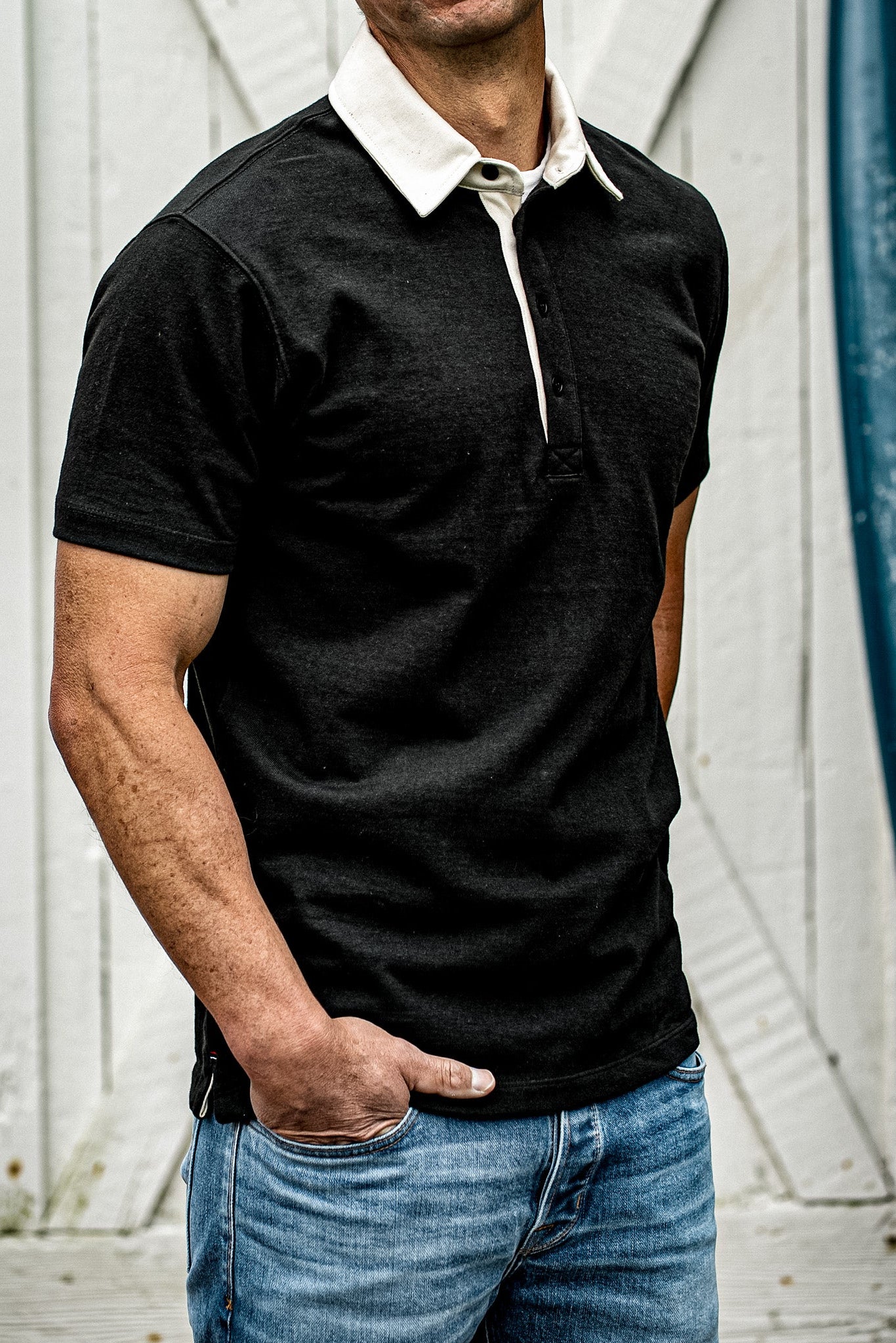 Men's black rugby polo shirt with white contrast collar, casual outdoor style
