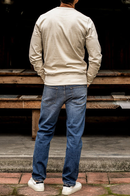 Best men’s premium jeans shown from the back, featuring a straight leg fit, medium blue wash, and minimal fade with clean pocket stitching for a modern, refined finish