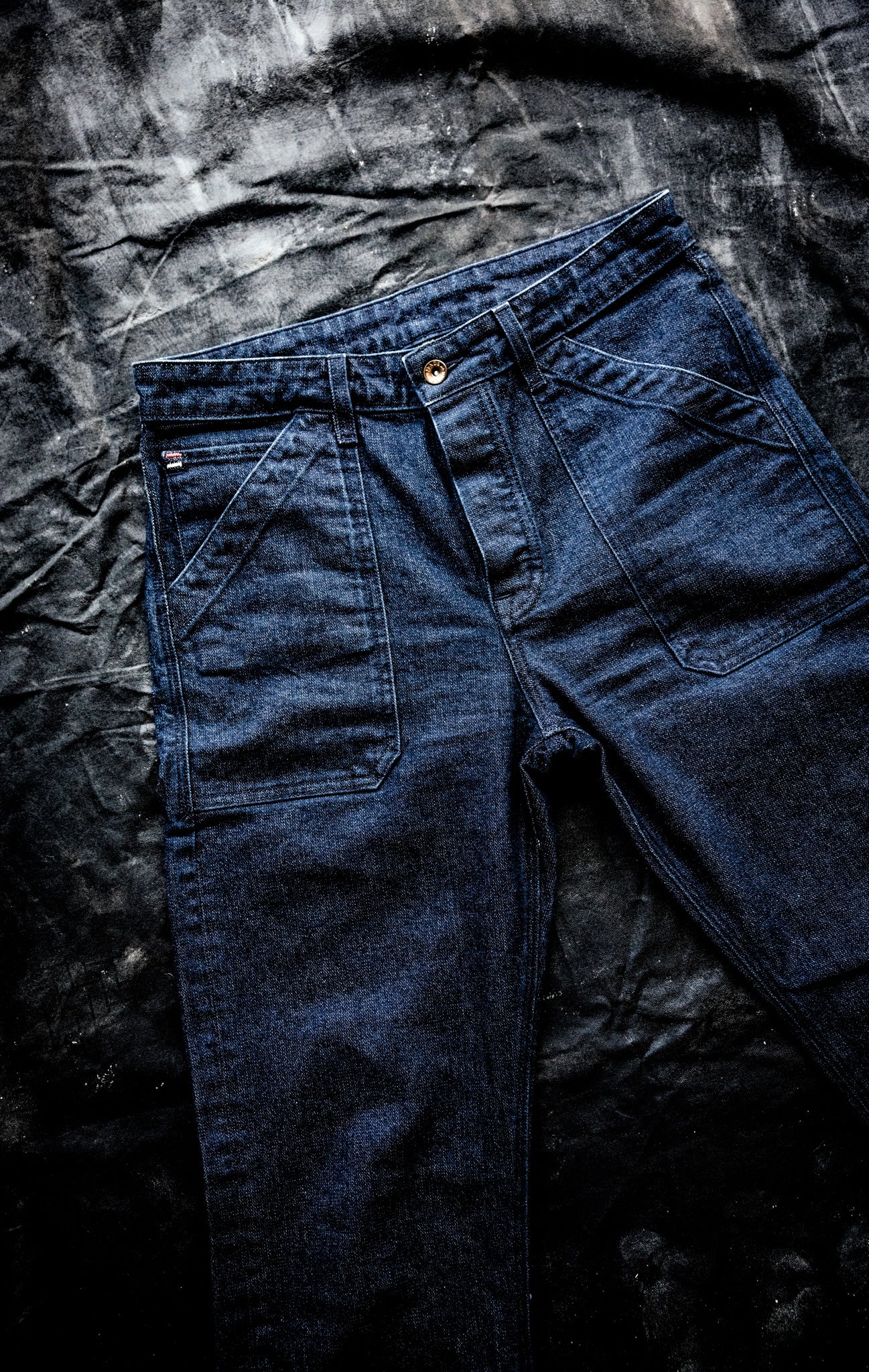 WiesMade Scout jeans in ocean indigo flat lay showing full front with patch pockets and carpenter seam detail.