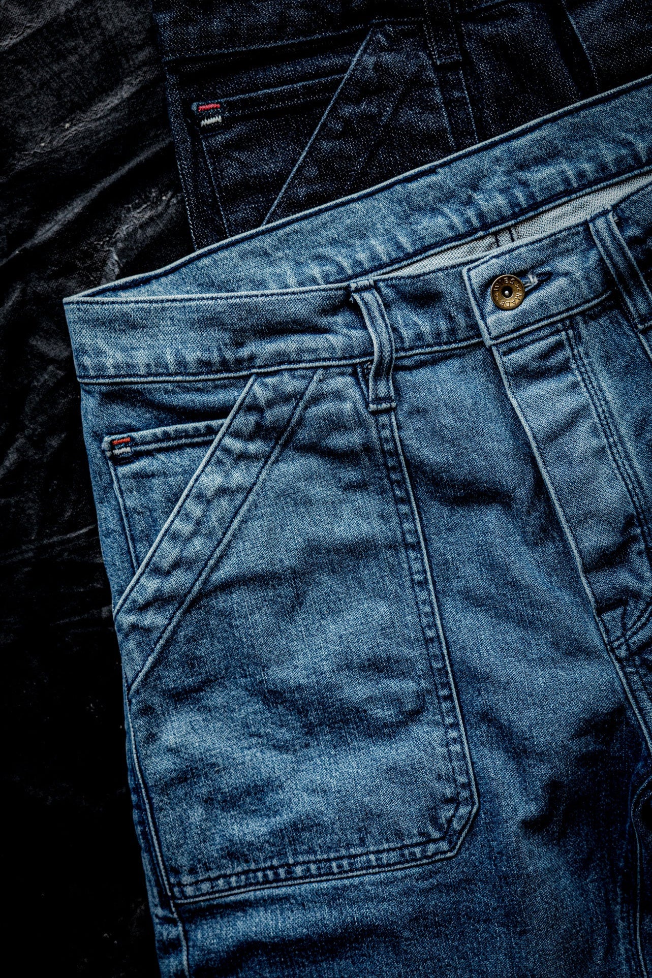 WiesMade Scout jeans in salt wash flat lay detail showing front yoke seam, carpenter pocket, and brass button fly.