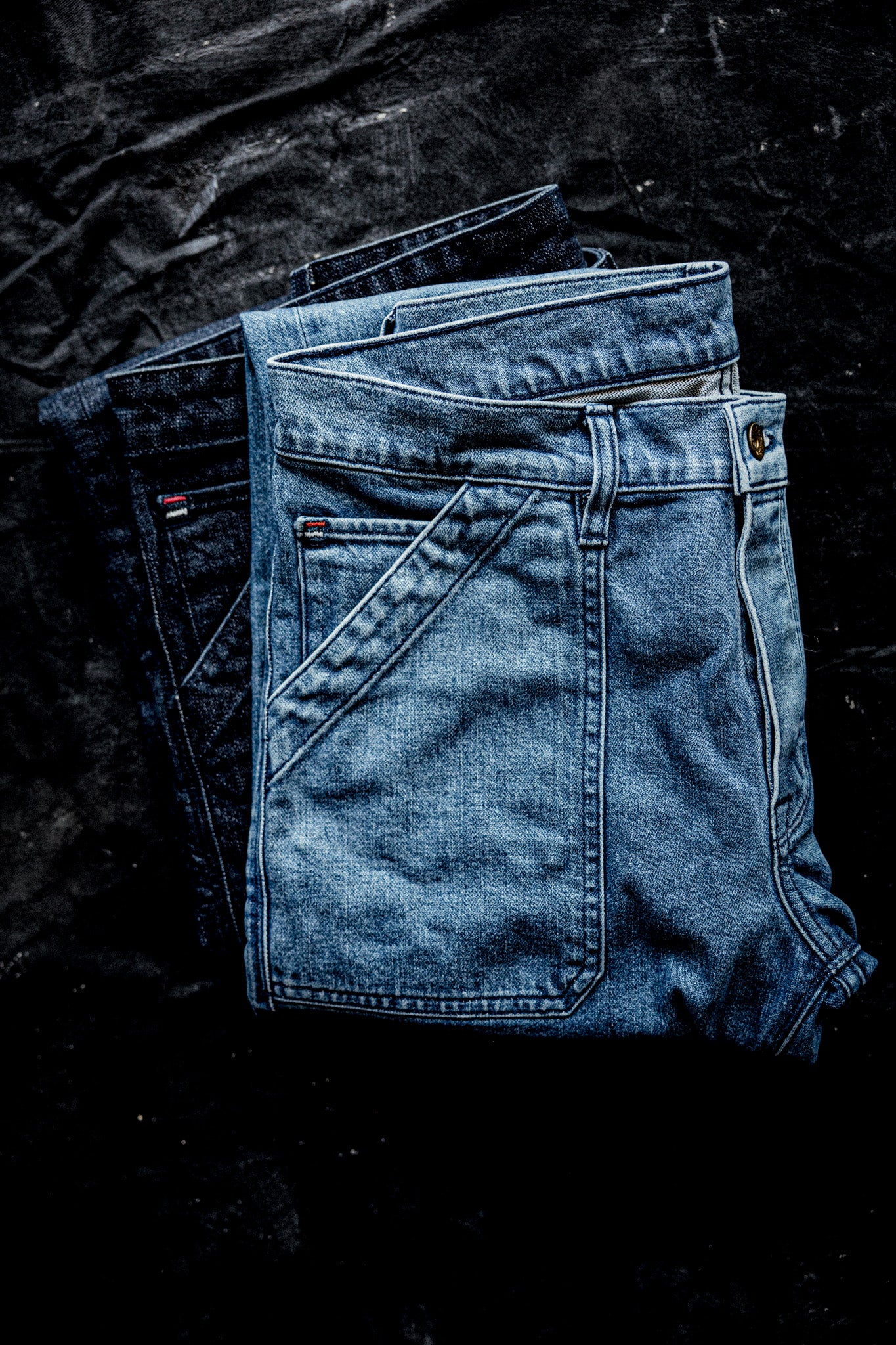 WiesMade Scout jeans in salt wash folded on a dark surface showing back yoke and pocket construction.