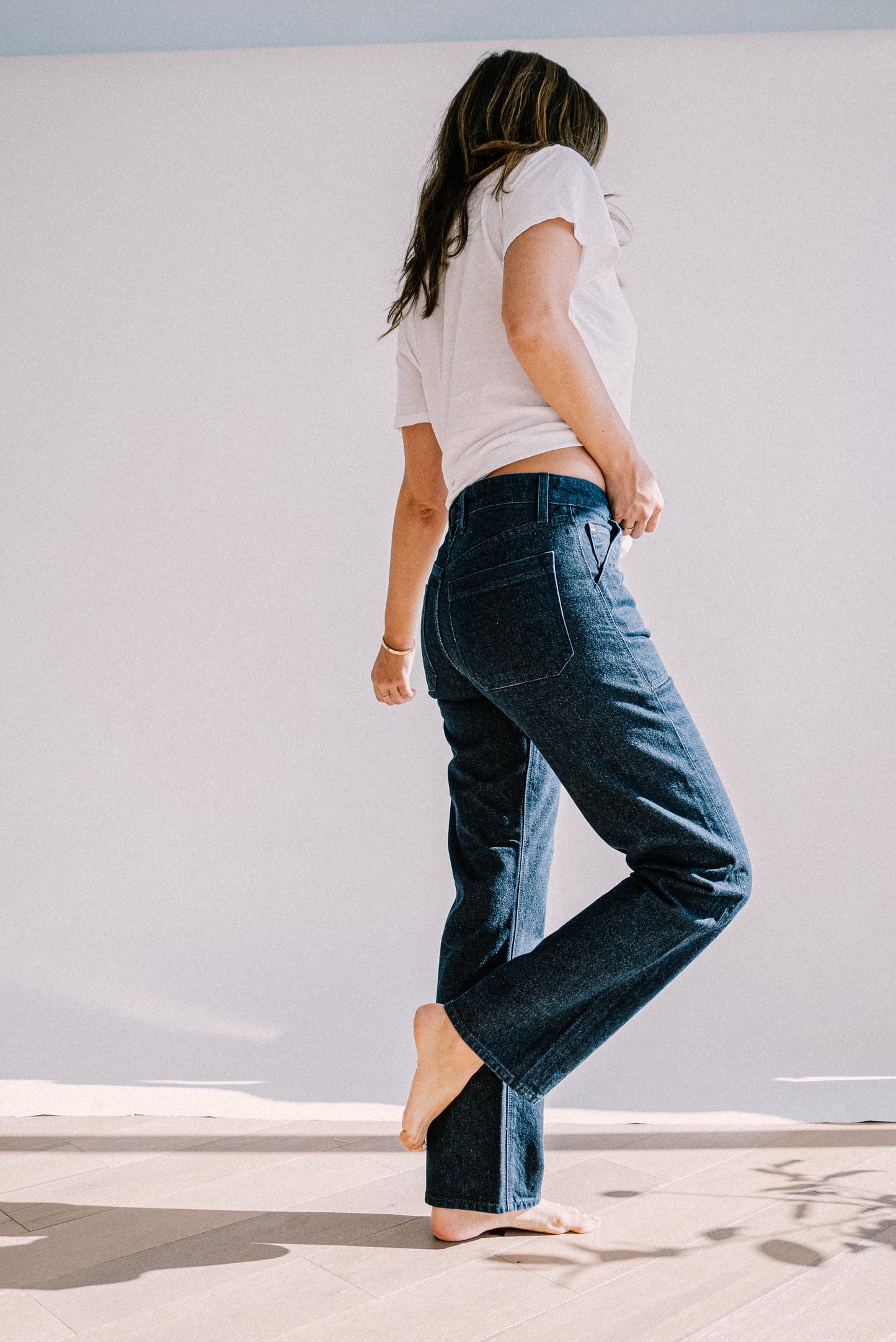 Premium denim jeans for women shown from side view, featuring a straight leg cut, structured seams, and a comfortable mid-rise fit for a modern, relaxed style