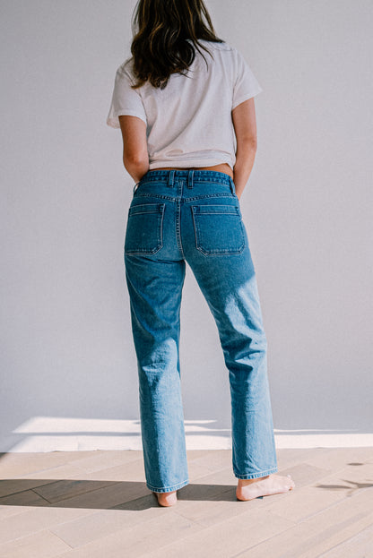Women’s salt wash designer jeans shown from the back, featuring a high waist fit, straight leg cut, and large back pockets for a clean, modern silhouette