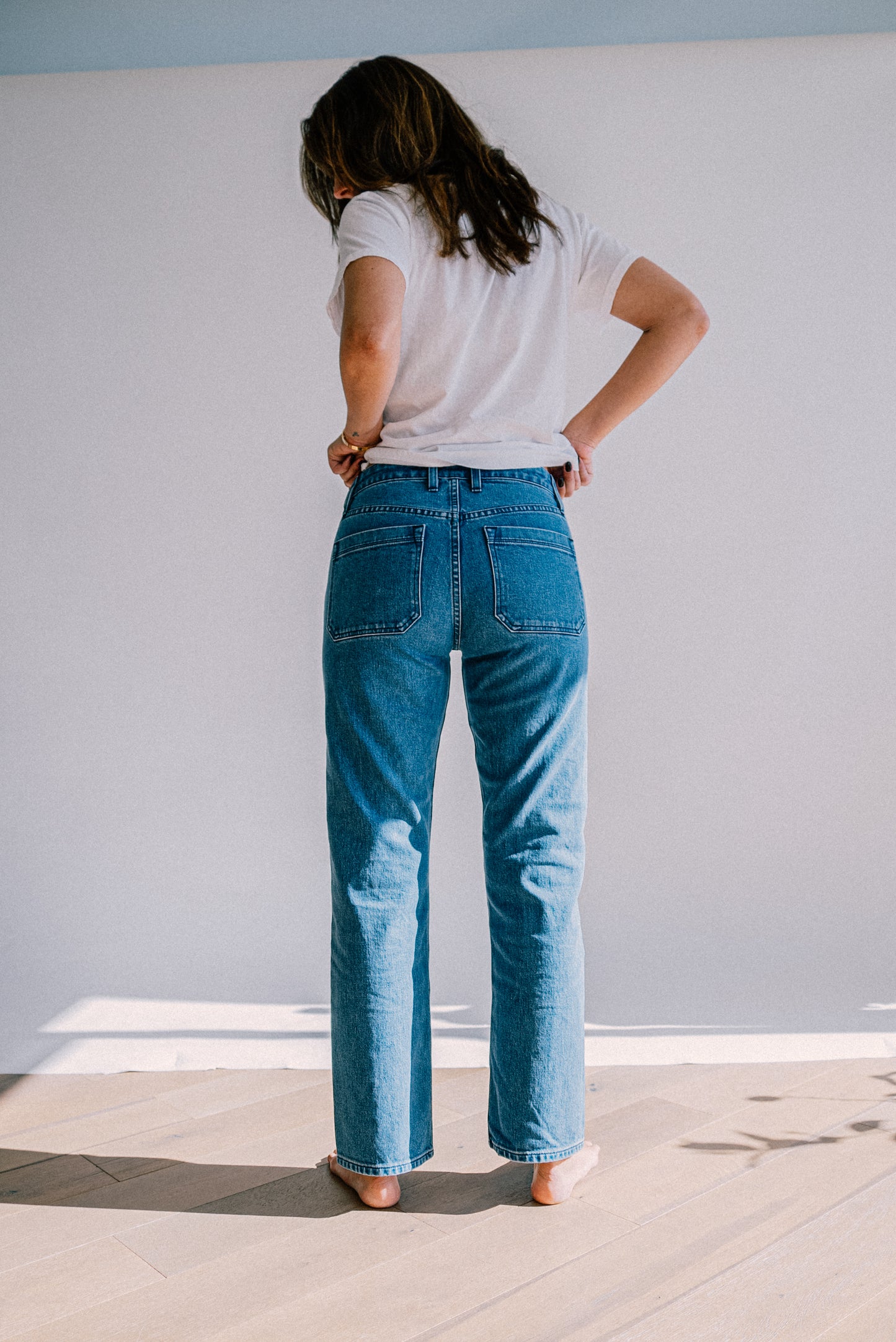 Premium salt wash jeans for women shown from the back, featuring a light blue wash, high rise fit, and straight leg design for a clean, relaxed look