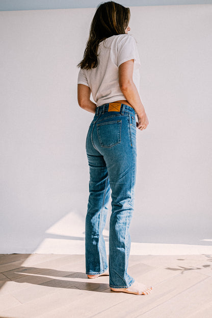 Back view of salt wash high-rise straight leg jeans with leather WiesMade patch, paired with a white tee.
