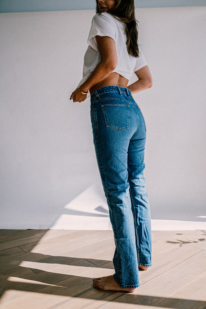 Back view of high-rise straight-leg American made denim jeans in salt wash, paired with a white tee.