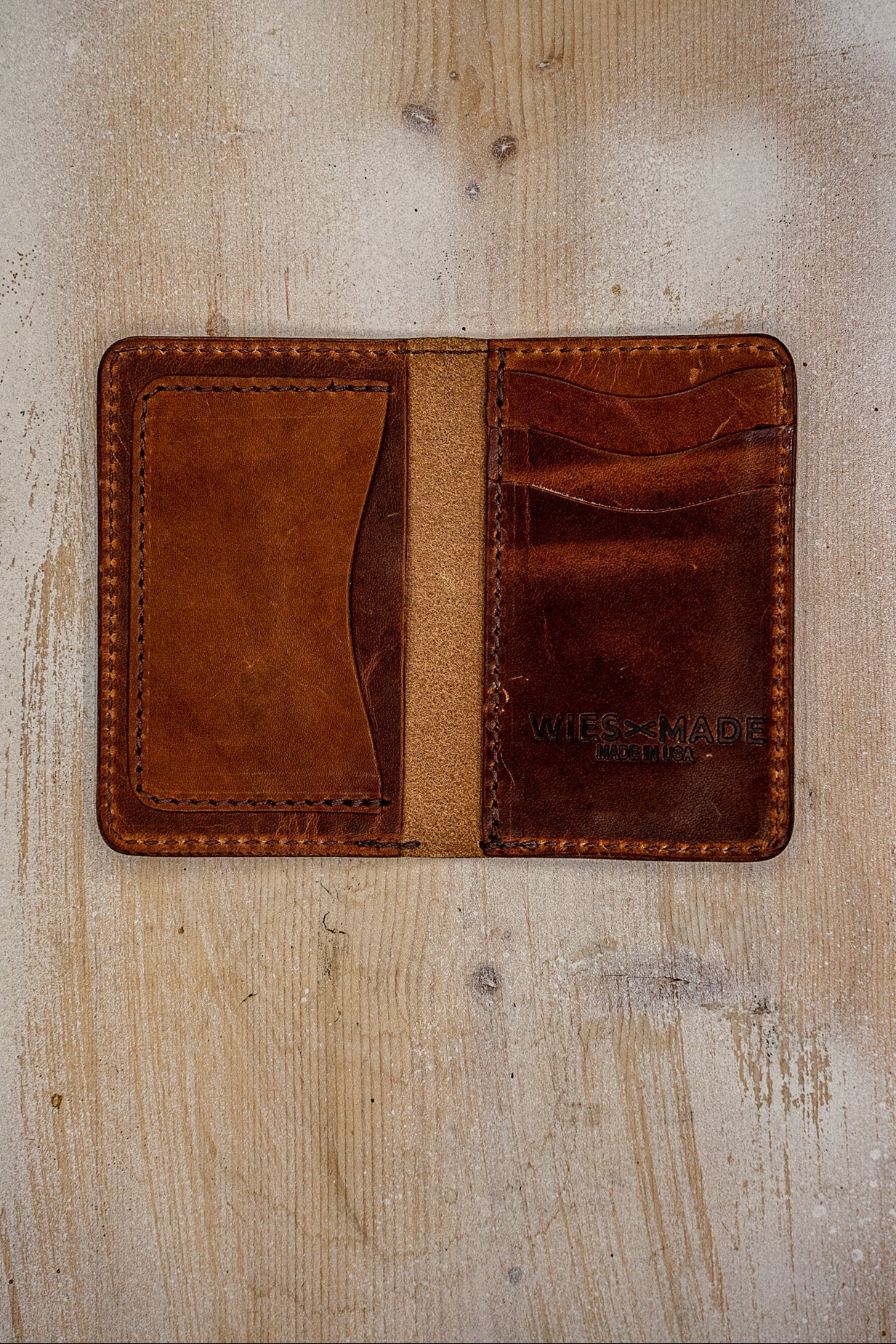 Open tan Horween leather bifold wallet showing card slots and WiesMade Made in USA stamp.