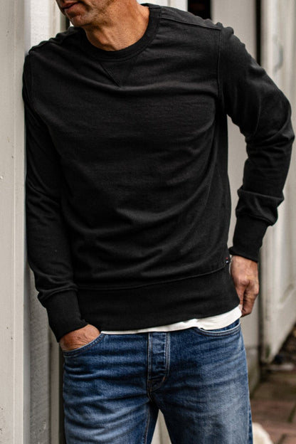 Basalt Stinson crewneck pullover in heavyweight cotton, layered over a white tee with blue jeans.