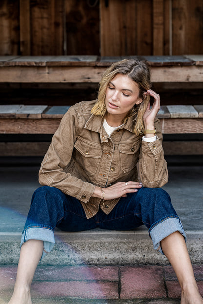 Wheat broken twill denim jacket worn with cuffed selvedge jeans on wooden steps.