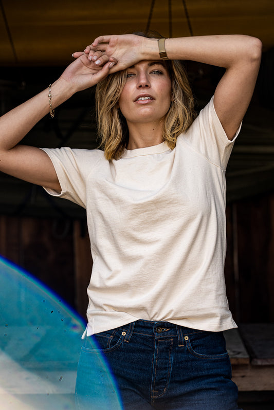 Model wearing the Reyes boxy tee in natural cotton paired with dark denim jeans.