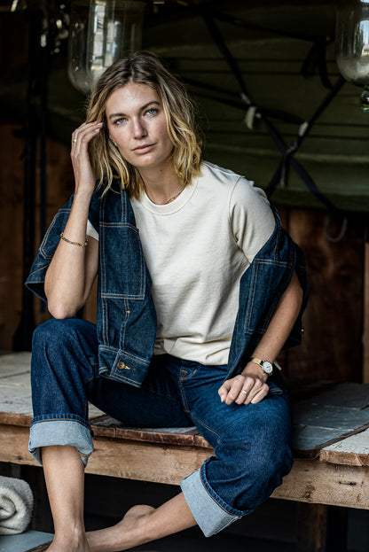 Model wearing the natural Reyes boxy tee styled with a raw denim jacket and cuffed jeans.