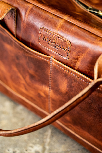 Embossed WiesMade Made in USA stamp on the tan Horween leather weekender bag pocket.
