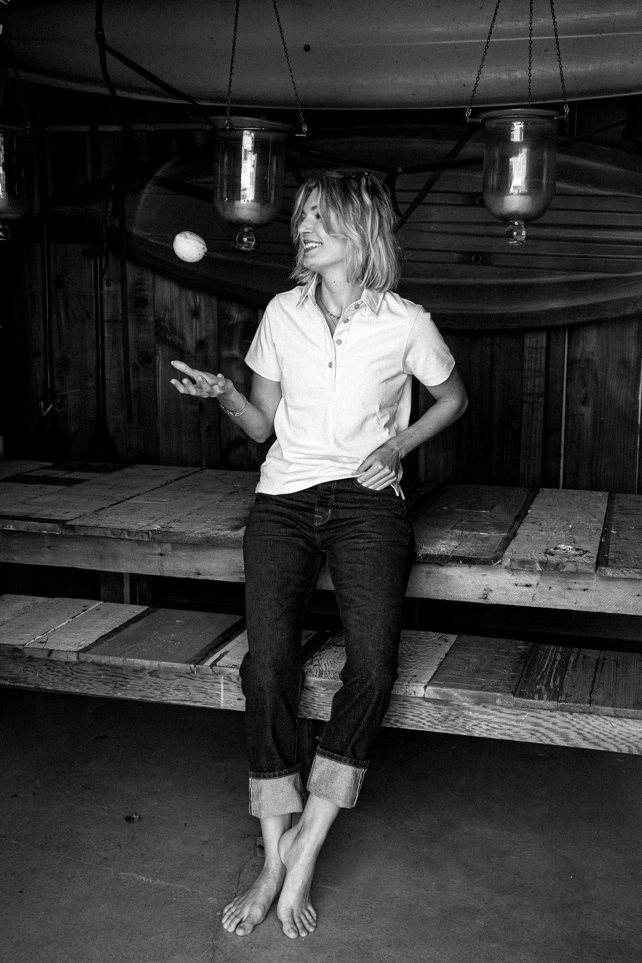 Woman in natural short-sleeve cotton rugby jersey and cuffed jeans, black-and-white lifestyle shot.