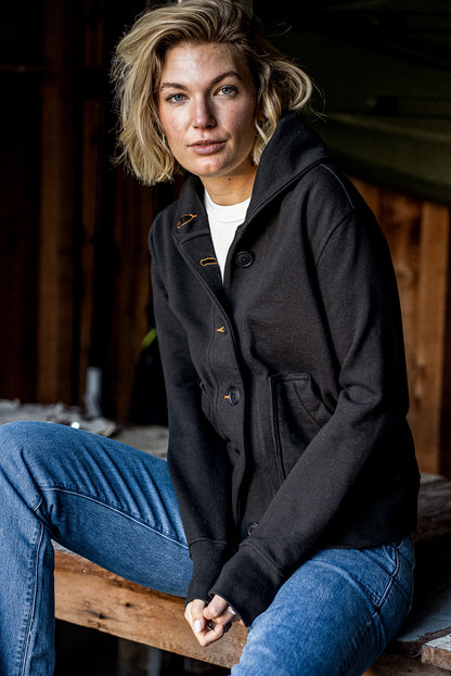 Model wears Bodega shawl-collar cotton French terry cardigan in Basalt with contrast tobacco keyholes.