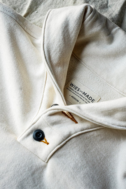 Close-up of the natural French terry shawl collar and black button placket with WiesMade interior label.