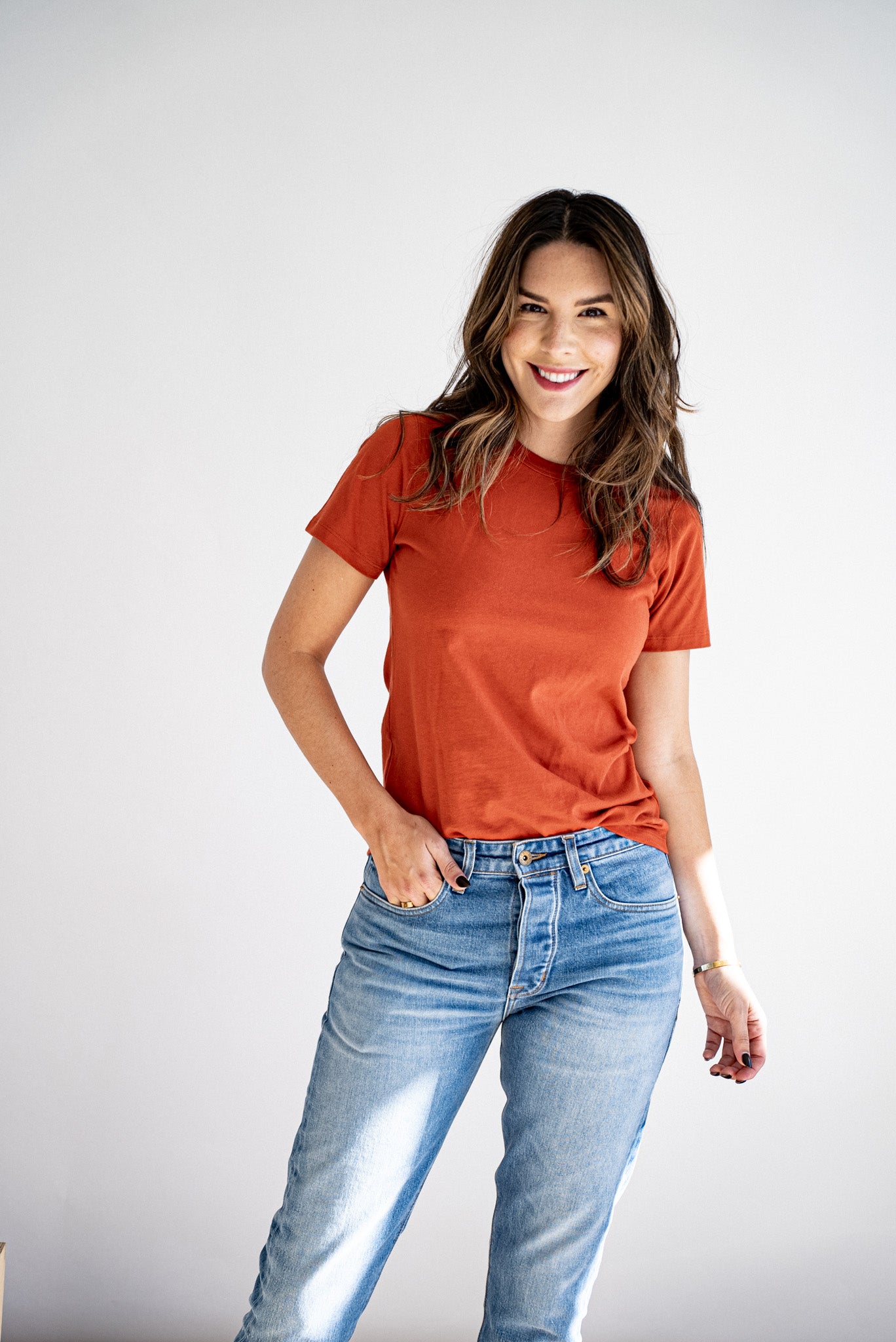 Woman wearing the Bolinas heavyweight tee in brick with light-wash jeans.