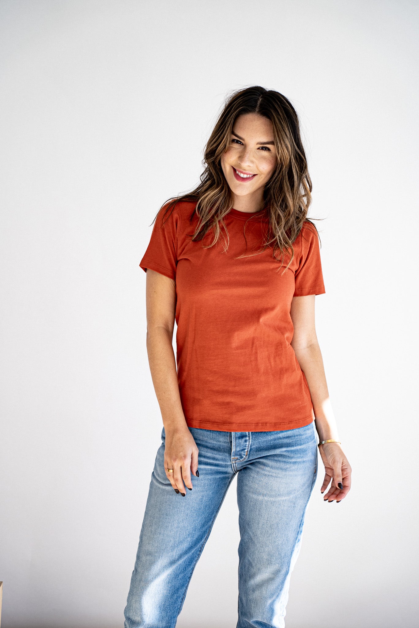 Woman wearing the Bolinas heavyweight tee in brick with light wash jeans.