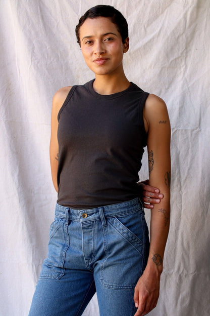 Model wearing the Bolinas basalt cotton tank tucked into light-wash denim jeans.