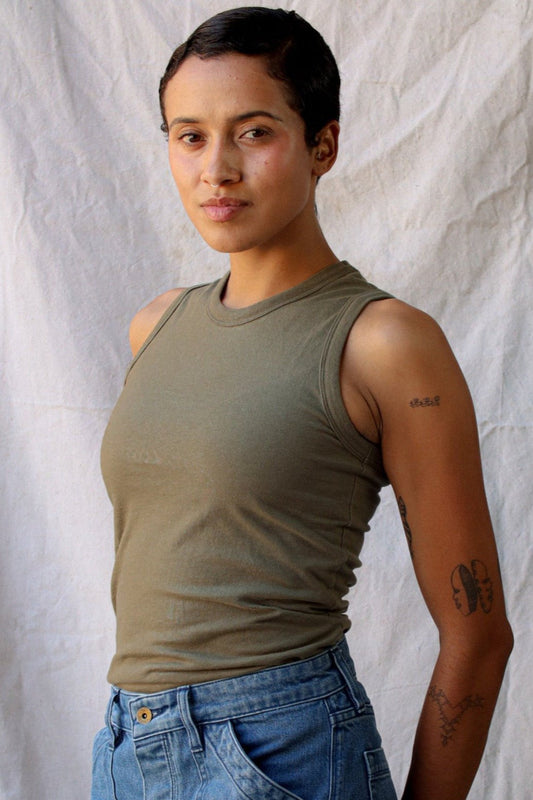 Model wearing the olive cotton Bolinas tank tucked into light-wash denim jeans.