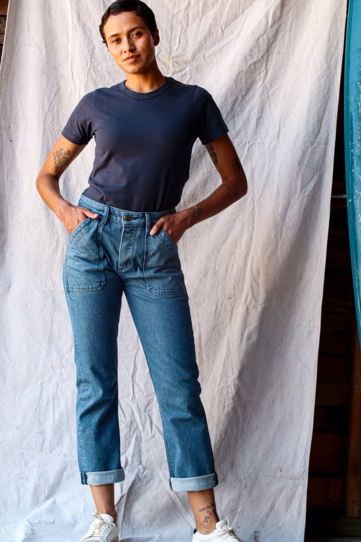 Model wearing the Bolinas heavyweight tee in polar dark slate, styled with cuffed blue jeans against a canvas backdrop.