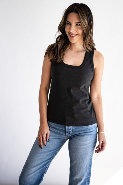 Model wears the basalt Reyes cotton tank tucked into light-wash jeans, scoop neckline visible.