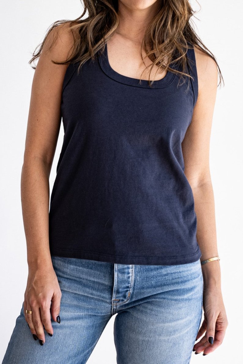 Woman wearing the navy Reyes boxy cotton tank tucked into light wash denim jeans.