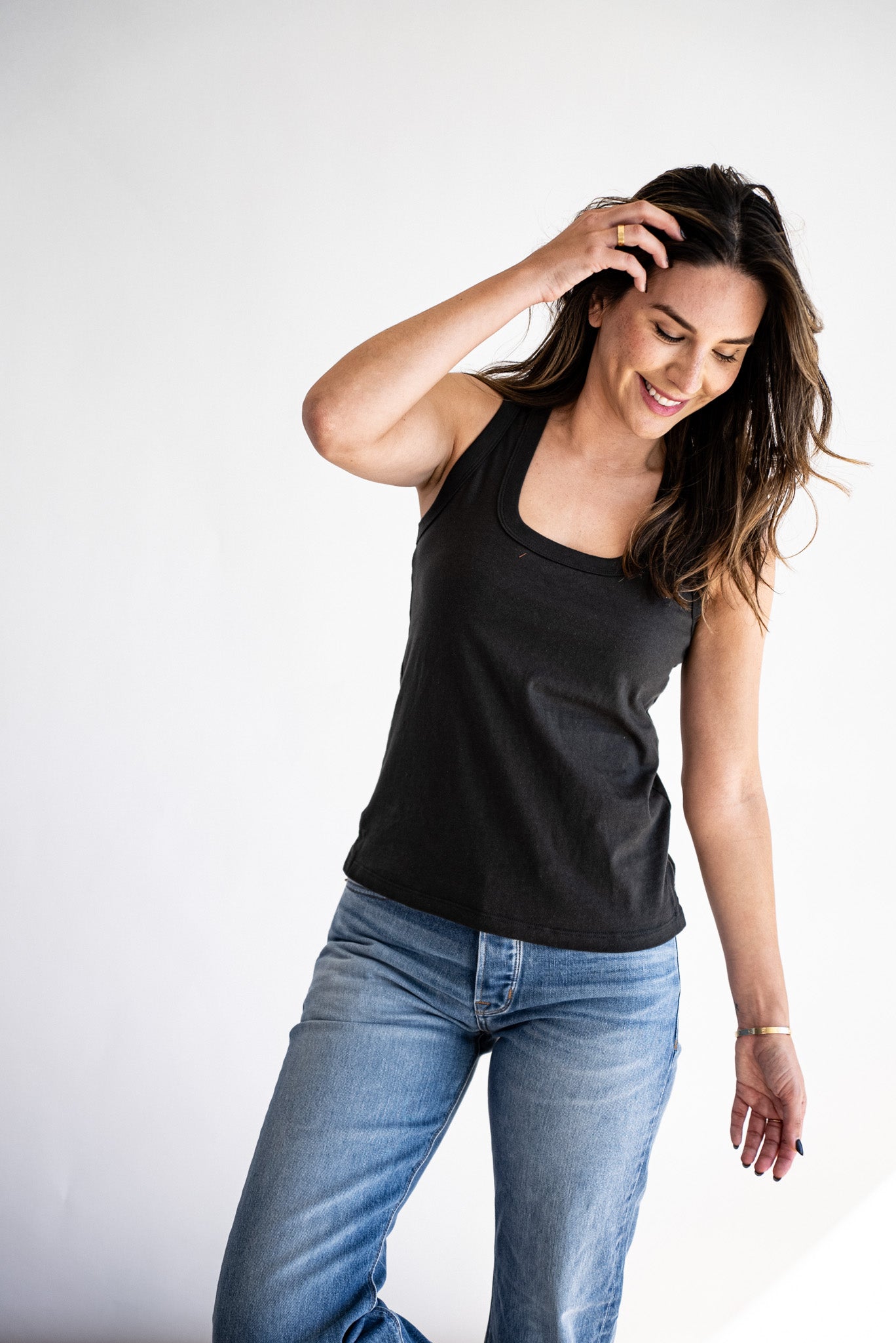 Model wearing the Reyes boxy cotton tank in basalt black with light wash jeans.