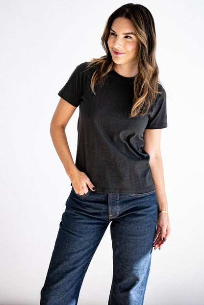 Woman wearing the Reyes boxy tee in basalt black with dark wash denim jeans.
