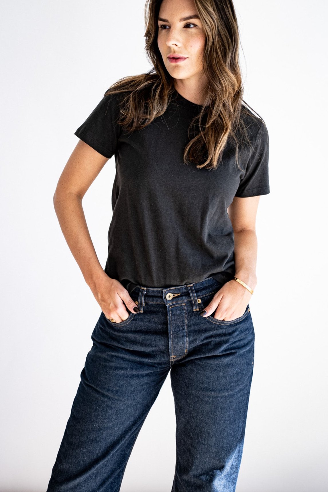Model wears the Reyes boxy tee in basalt black tucked into dark wide-leg denim jeans.