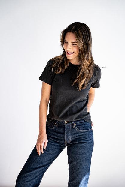 Woman wearing the Reyes boxy tee in basalt black, styled with dark wash denim jeans.