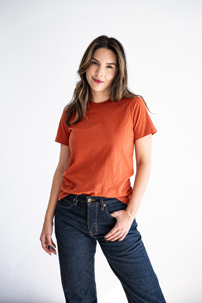 Model wearing the Reyes boxy tee in brick with dark raw denim jeans.