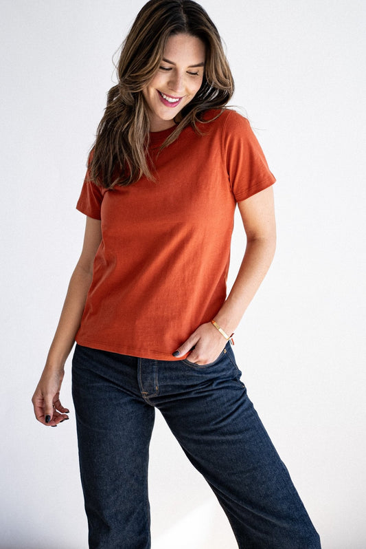 Brick orange Reyes boxy tee styled with dark raw denim jeans.
