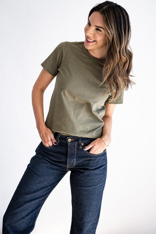 Model wearing the olive Reyes boxy tee styled with dark wash denim jeans.