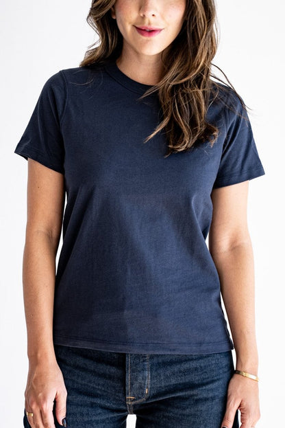 Woman wearing a relaxed-fit boxy cotton tee in dark navy, paired with denim jeans.